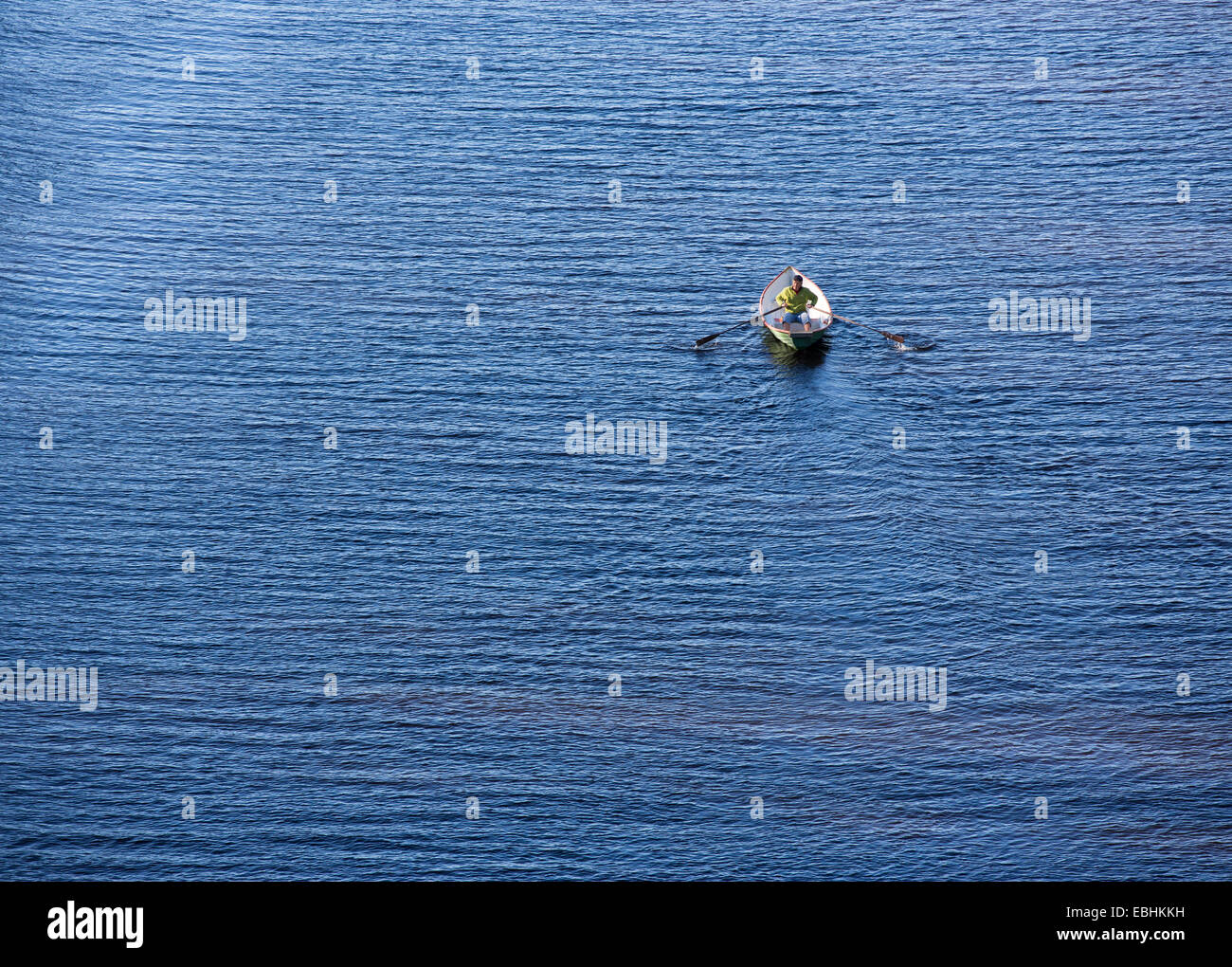 Aerial view of an elderly man rowing a fiberglass rowboat / skiff / dinghy , Finland Stock Photo