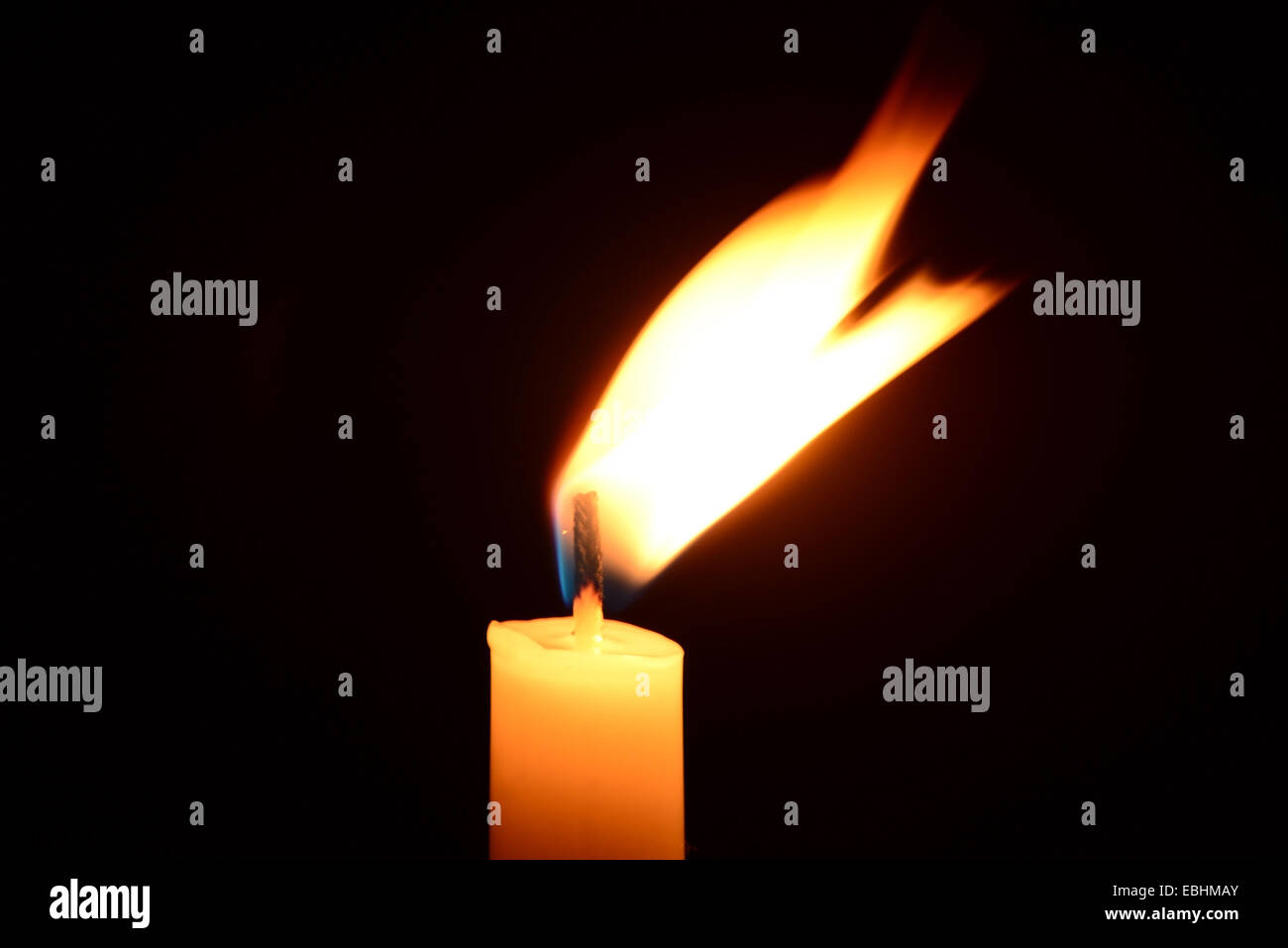 White candle burning on a black background Stock Photo - Alamy
