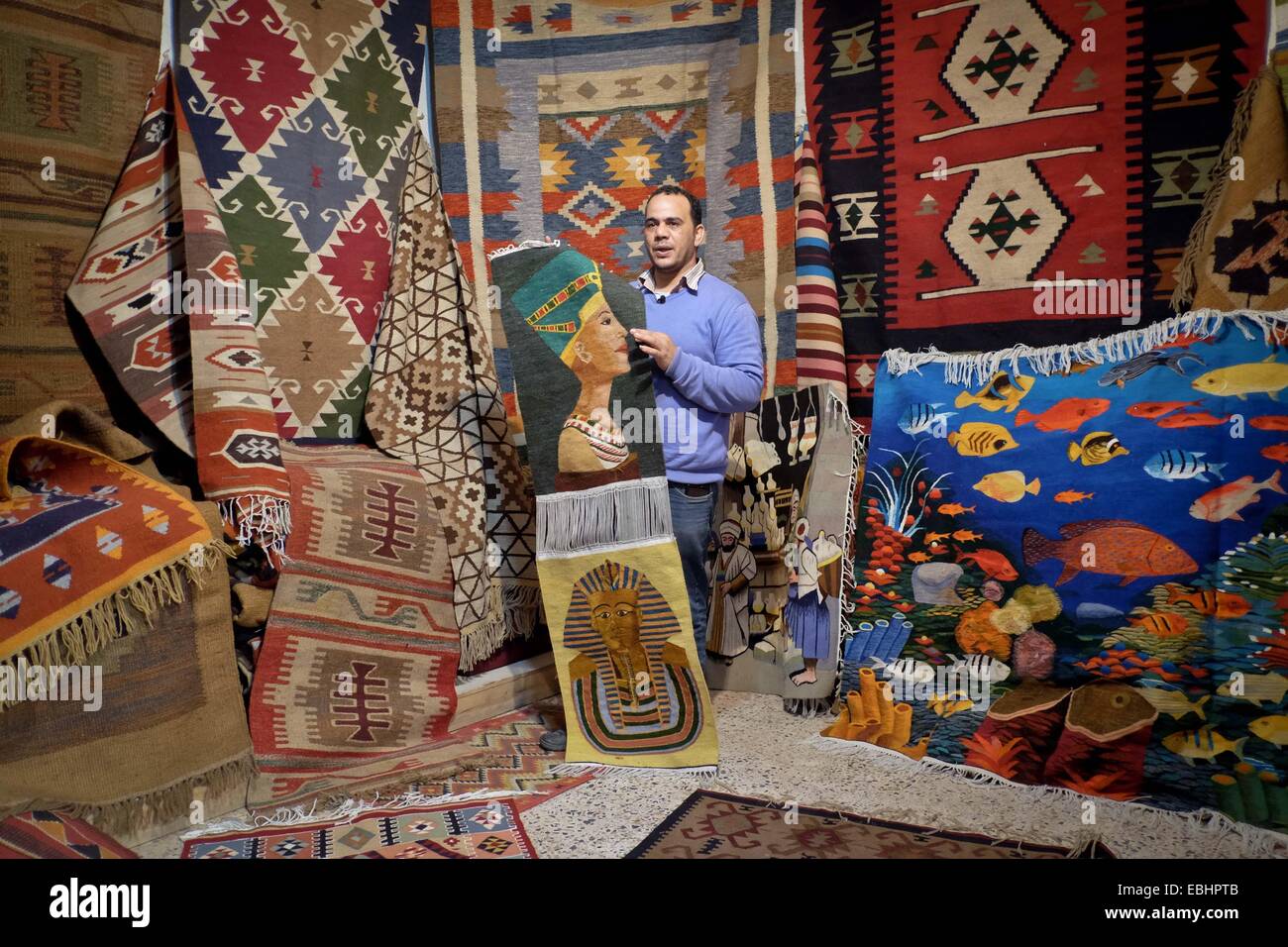 Giza, Egypt. 1st Dec, 2014. Ibrahim Eid, a carpet shop owner, displays