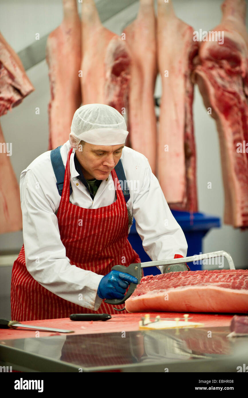 A butcher sawing a joint of meat Stock Photo