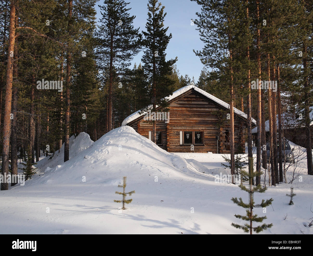 Romantic snow covered wintersport chalet between the pine trees in a holiday resort in Lapland, Finland. Stock Photo