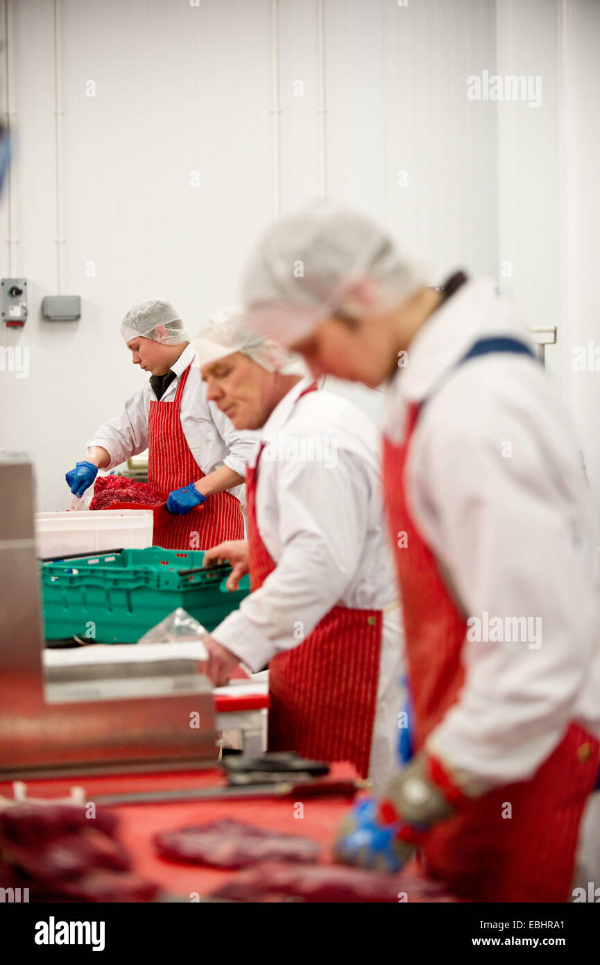 Butchers at work in a meat processing factory Stock Photo