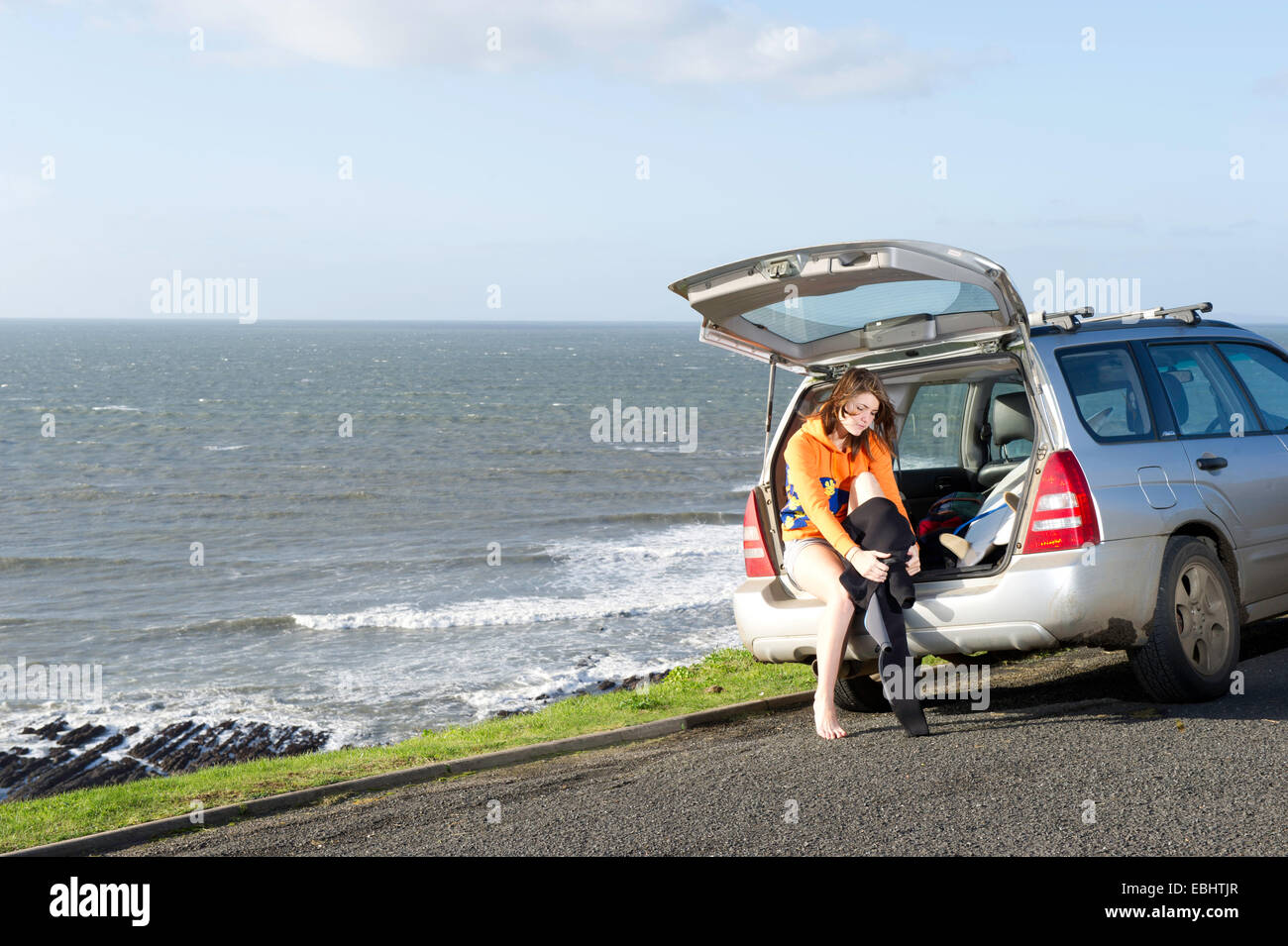 A girl getting out of her car and into her wetsuit Stock Photo