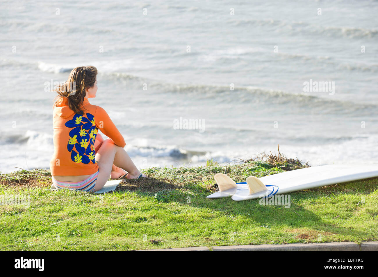 Girl surfer looking at waves Stock Photo