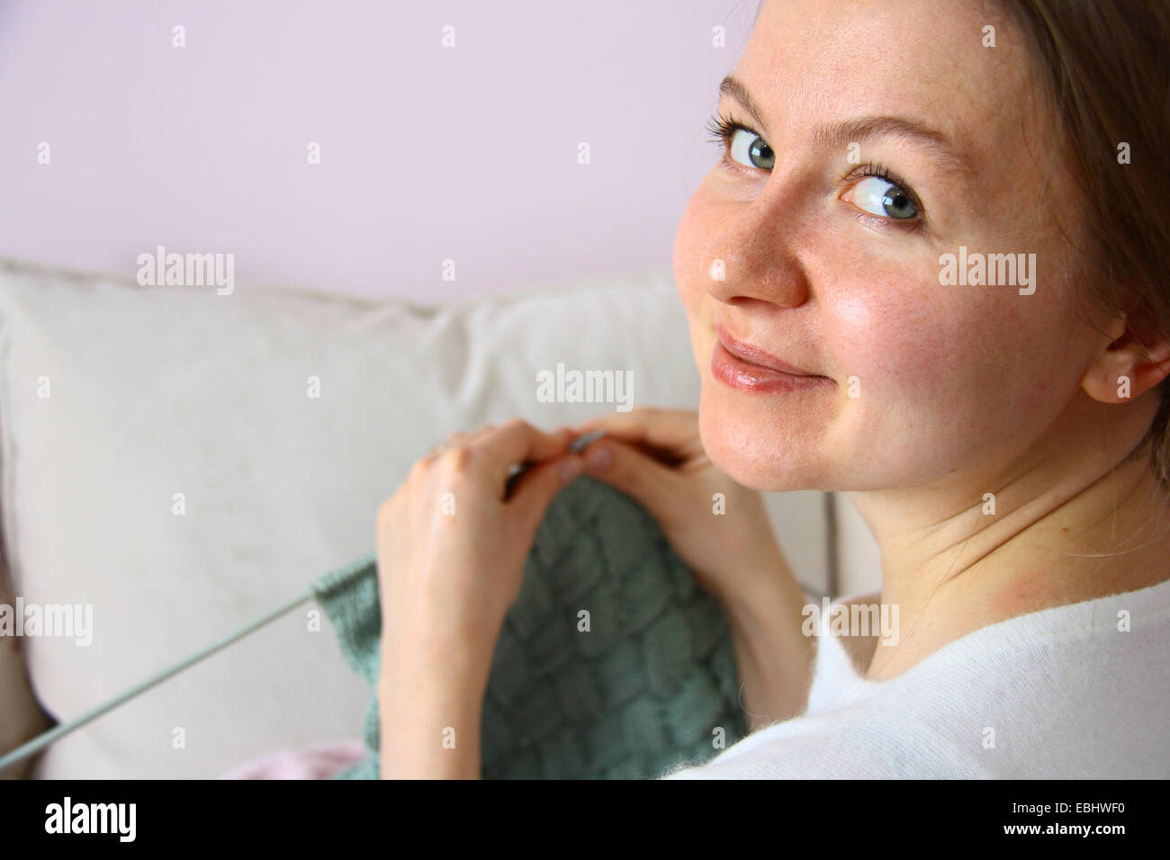 happy young woman knitting on sofa Stock Photo - Alamy