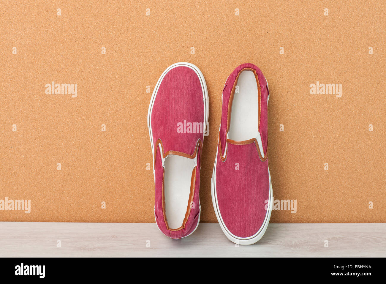 Red Sneaker on a Wood Background, slip-on shoes Stock Photo