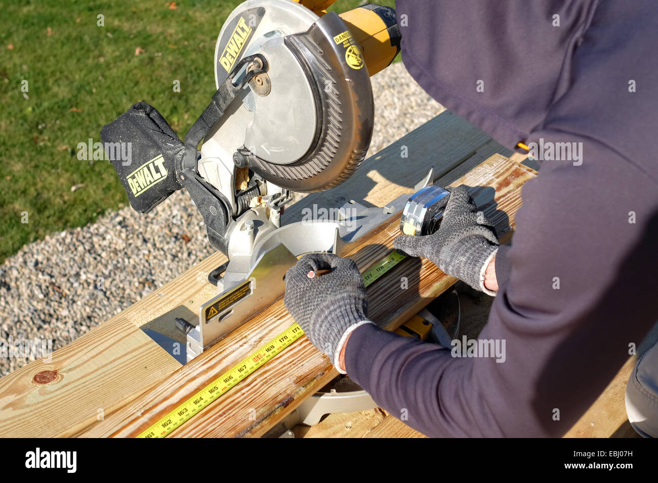 Man measures wood before cutting it with a miter saw Stock Photo Alamy