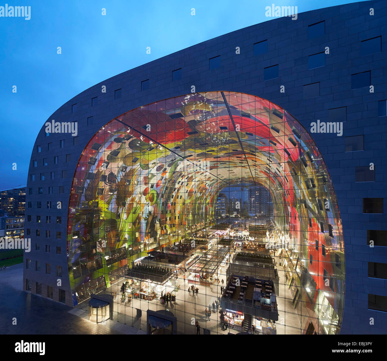 Market Hall Rotterdam, Rotterdam, Netherlands. Architect: MVRDV, 2014. Dusk elevation with illuminated and glowing interior. Stock Photo
