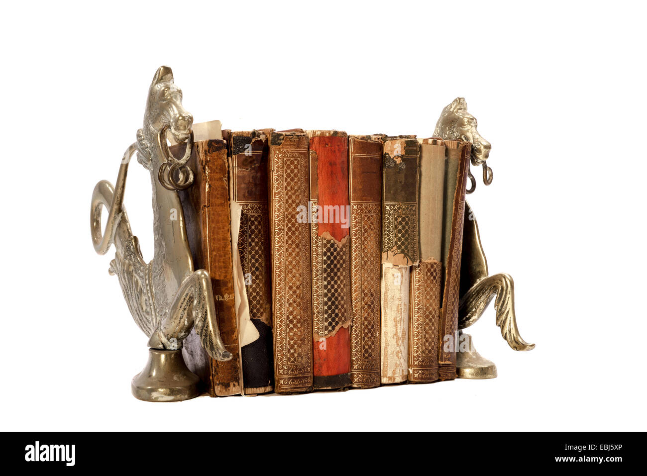 Eight old neglected and torn books between two book stands made of copper and resembling horses, photographed on an isolated whi Stock Photo