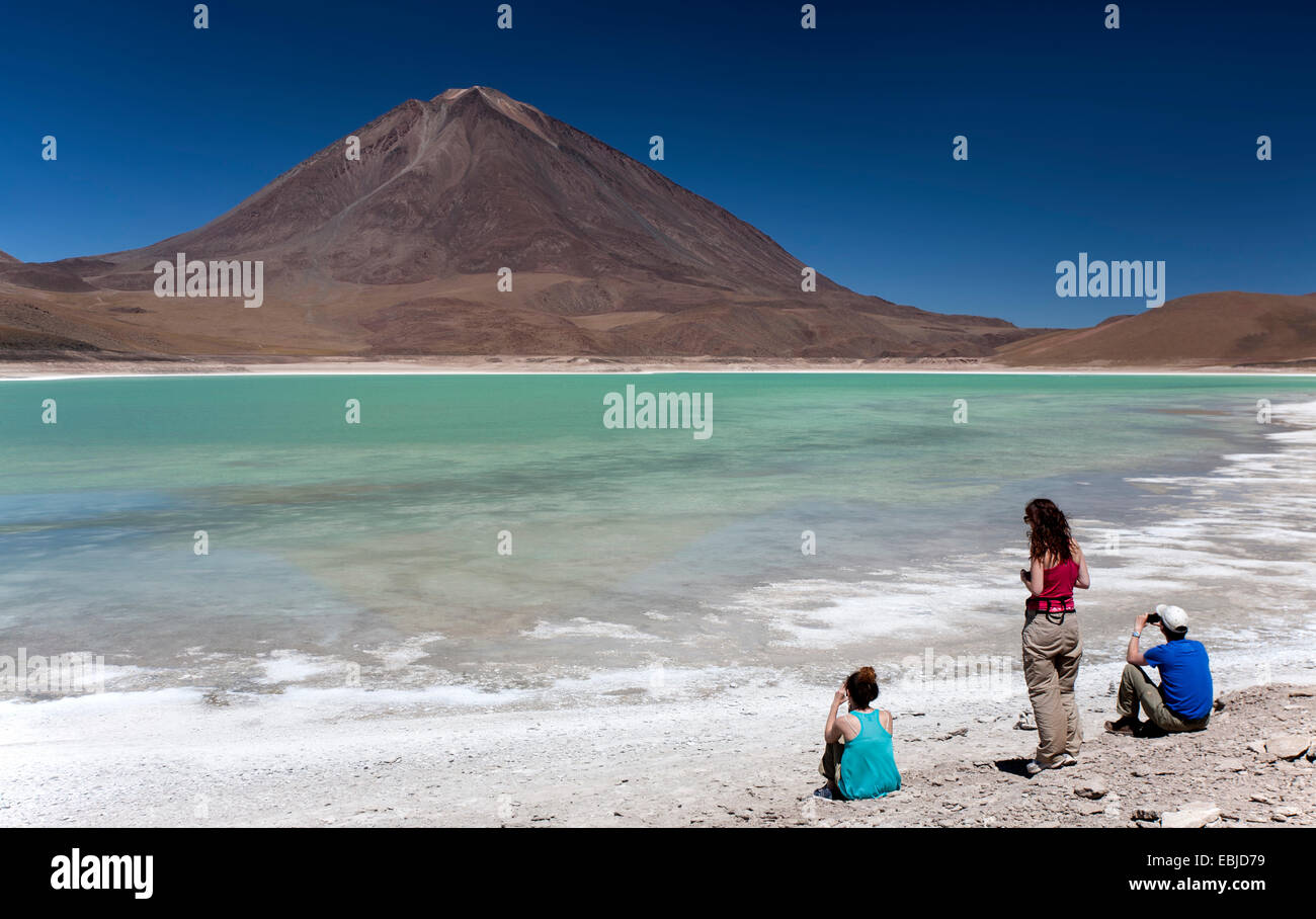 Tourists contemplating the Laguna Verde (green lagoon) and Licancabur volcano. Tour to Salar de Uyuni. Bolivia Stock Photo