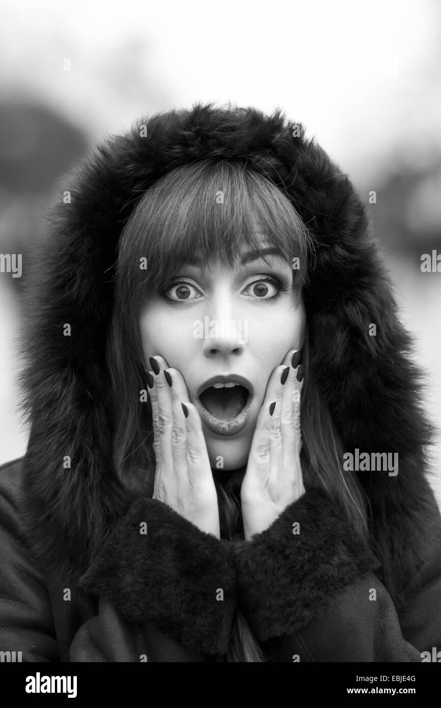 Black and white portrait of young amazed woman at the street Stock Photo