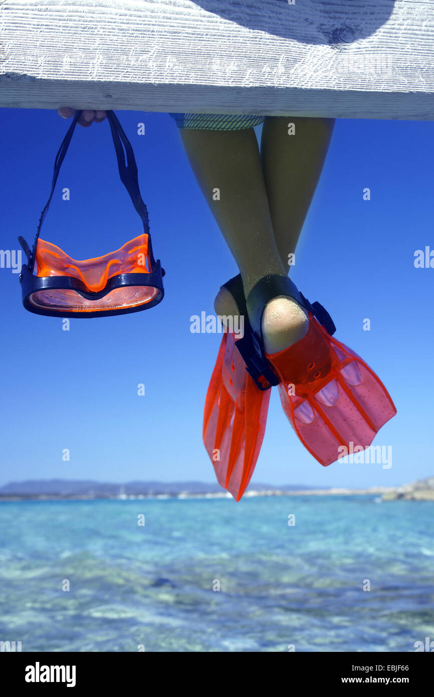 diving goggles and legs with flippers on a boardwalk Stock Photo