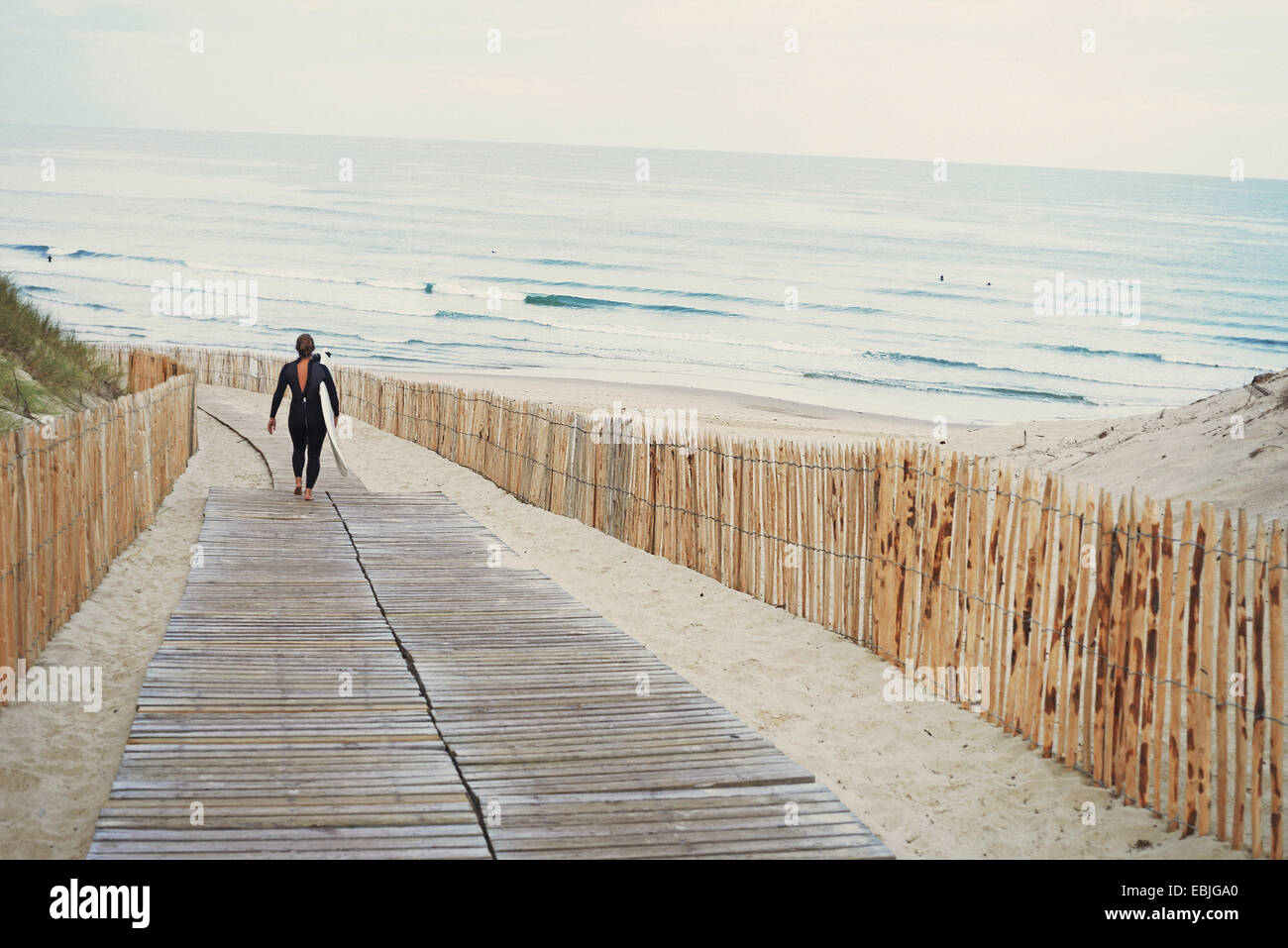 Surfer with surfboard walking to beach, Lacanau, France Stock Photo