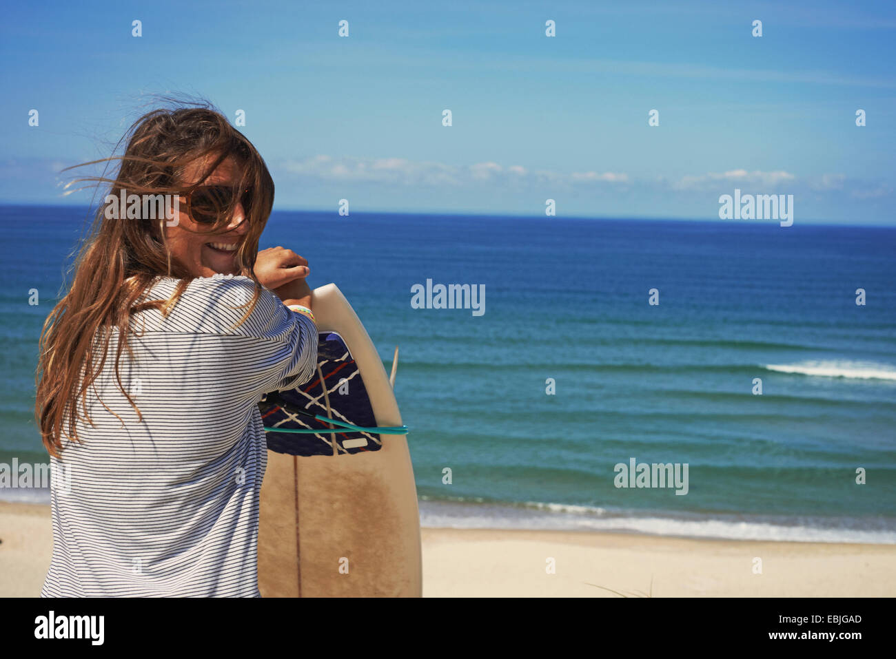 Woman with surfboard on beach, Lacanau, France Stock Photo