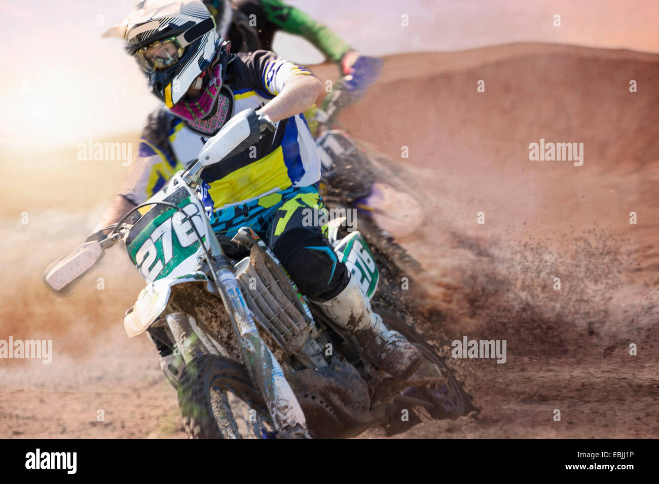 Two young male motocross riders racing on muddy track Stock Photo