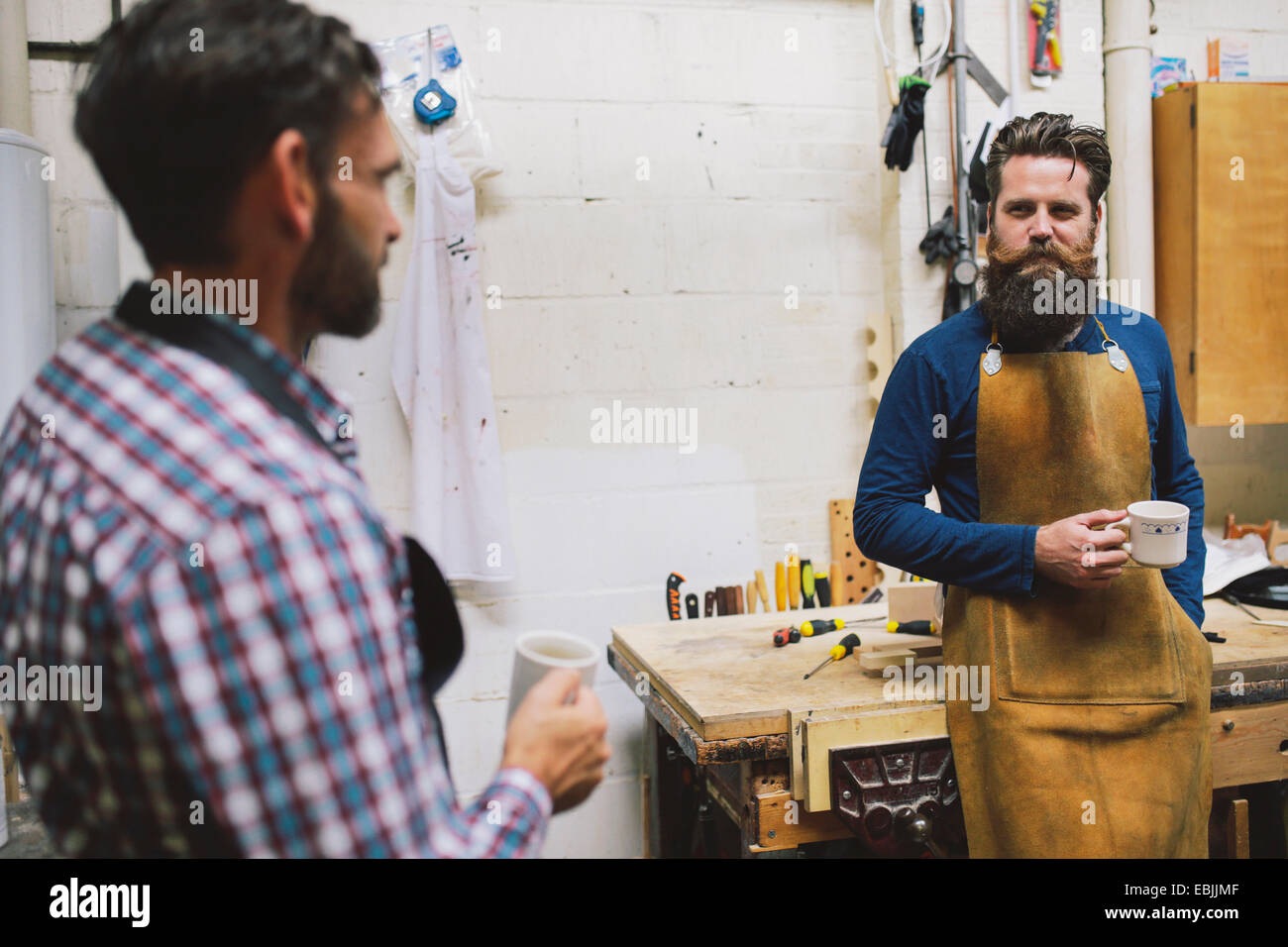 Two craftsmen chatting in pipe organ workshop Stock Photo