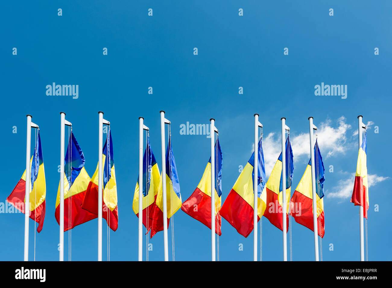 Romanian Flag Poles On Blue Sky Stock Photo