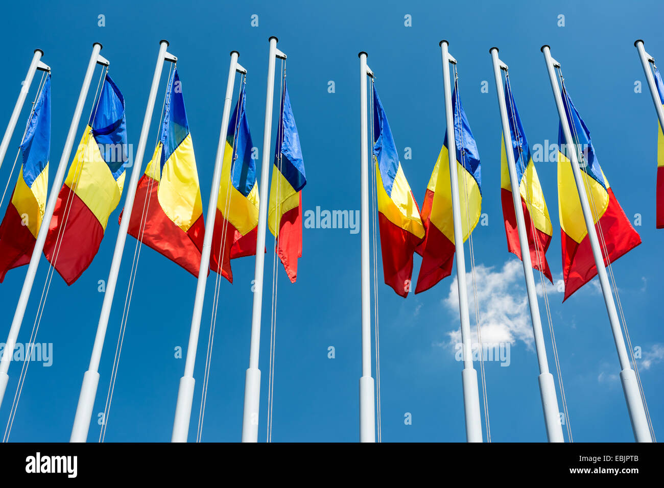 Romanian Flag Poles On Blue Sky Stock Photo
