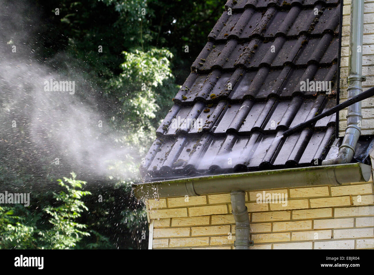 cleaning the roof and facade of a gabled house with a high-pressure water blaster, Germany, Nordrhein Westfalen, Ruhr Area, Essen Stock Photo