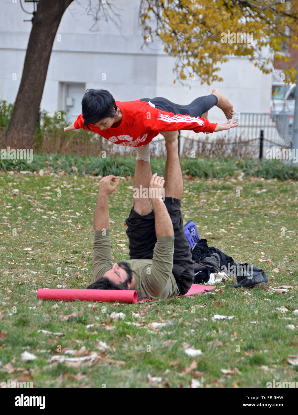 A couple doing balancing exercises in Washington Square Park in Greenwich Village, Manhattan, New York City Stock Photo