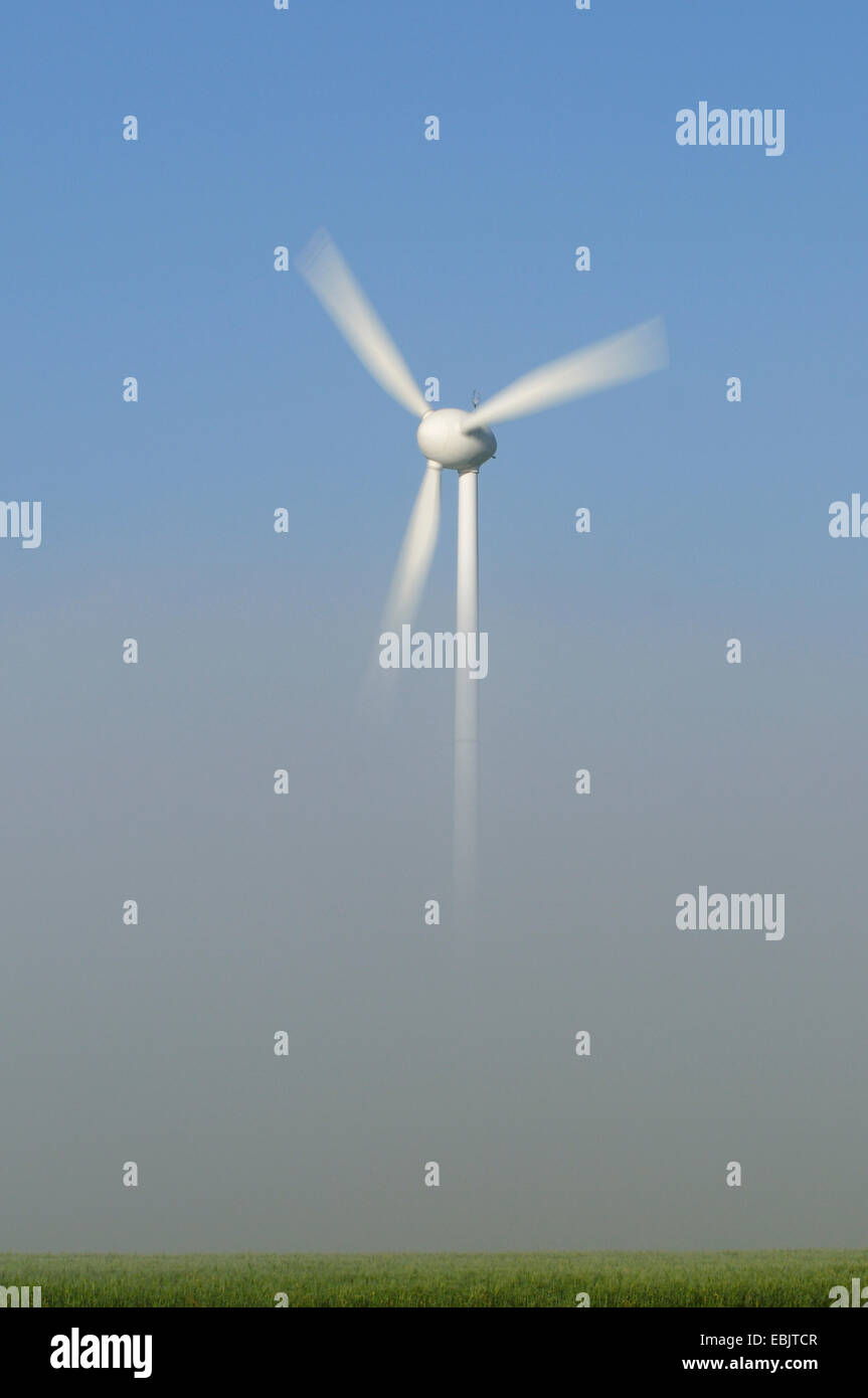 single wind wheel poking out of the morning mist, Germany Stock Photo