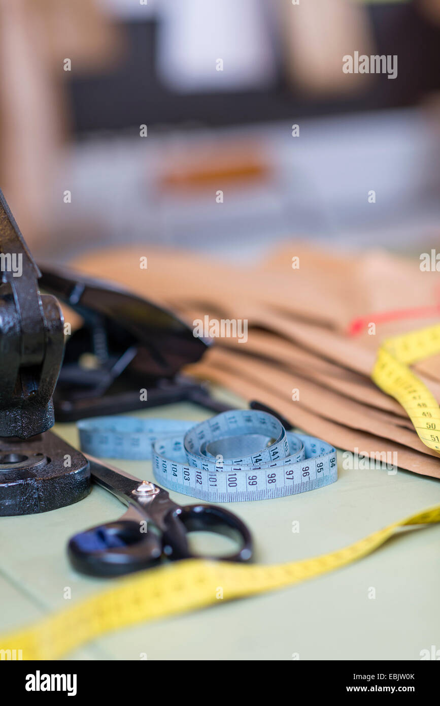 Dressmakers pattern, scissors and tape measure on work table in workshop Stock Photo
