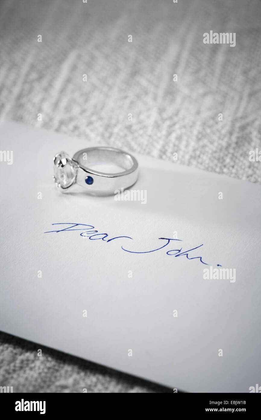 Returned engagement ring on a Dear John letter. Stock Photo