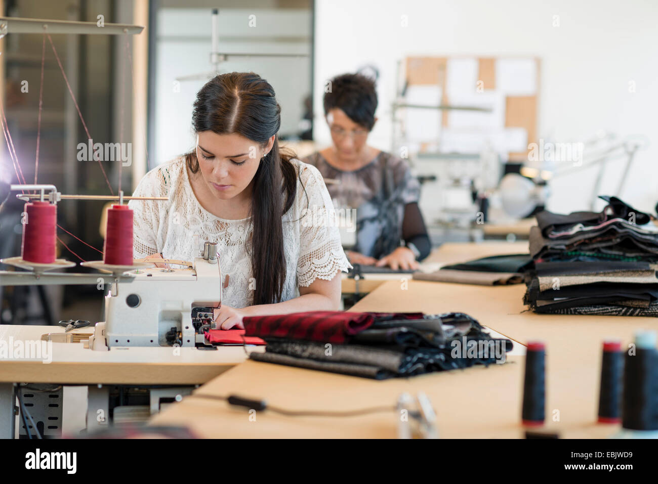 Two seamstresses using sewing machines in workshop Stock Photo