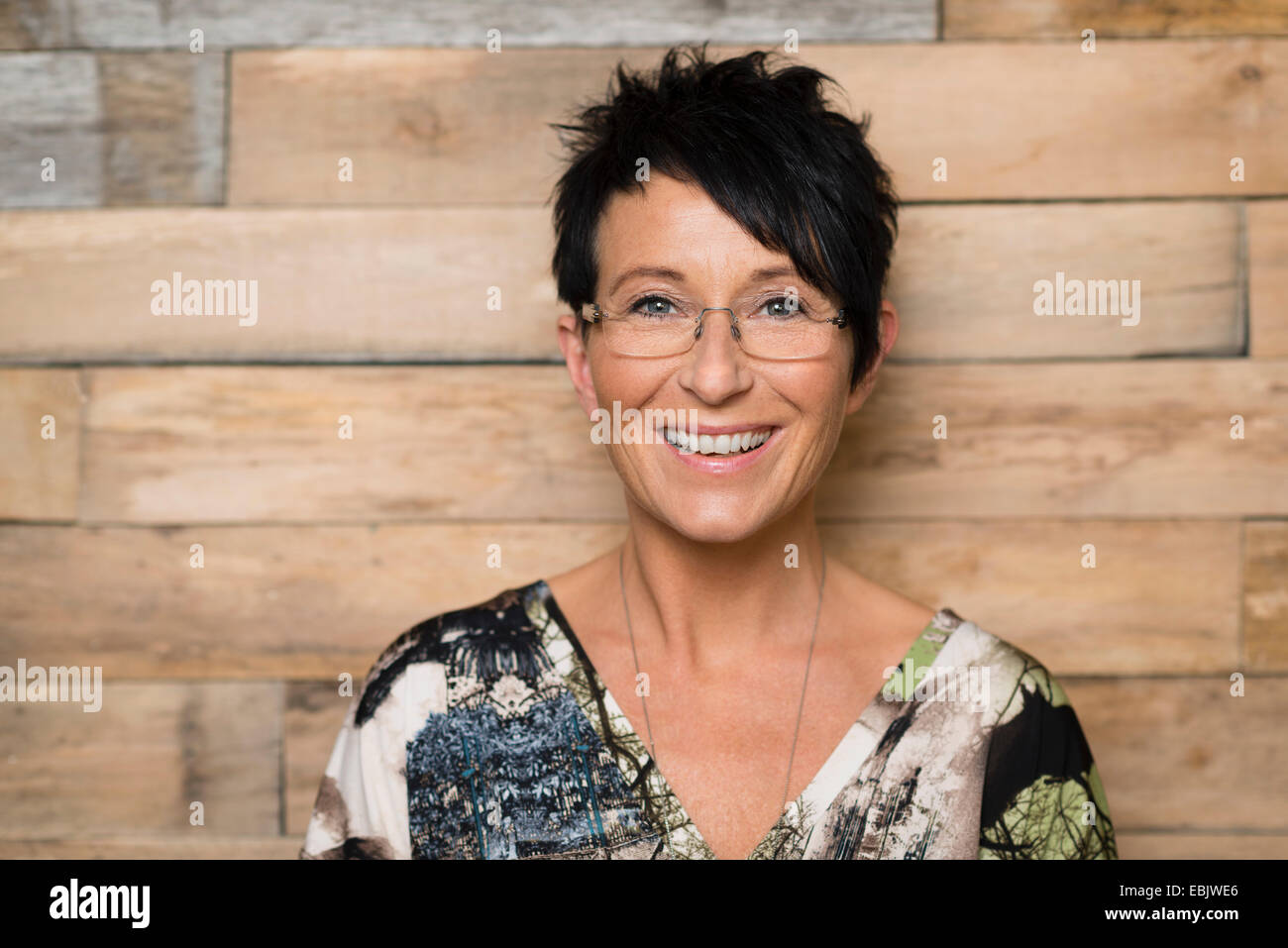 Portrait of mature seamstress in front of workshop wall Stock Photo