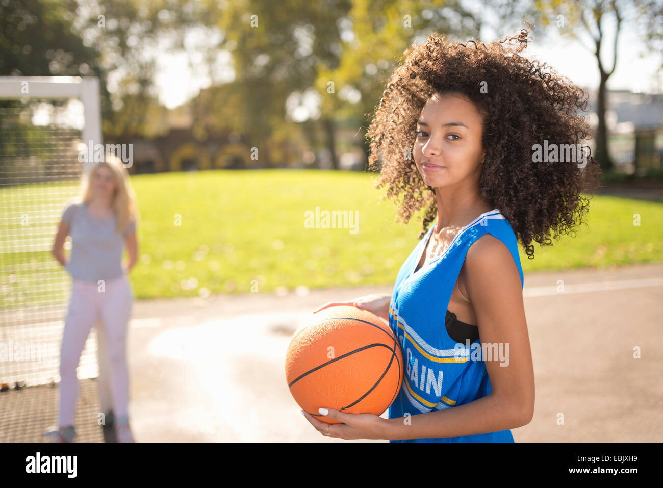 Portrait of young woman holding basketball Stock Photo