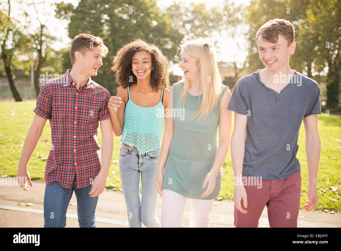 Four young adult friends strolling in park Stock Photo