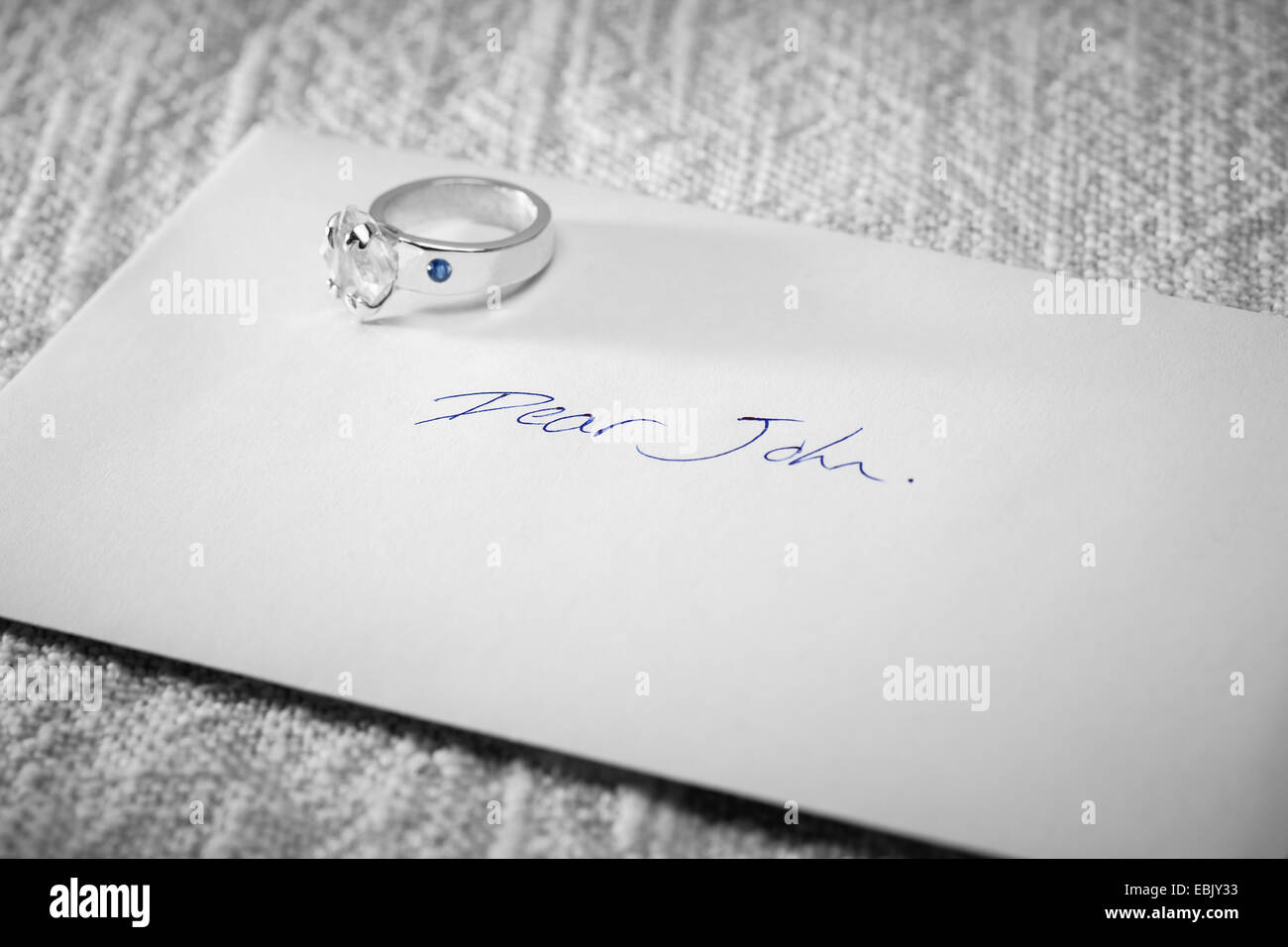 Returned engagement ring on a Dear John letter. Stock Photo