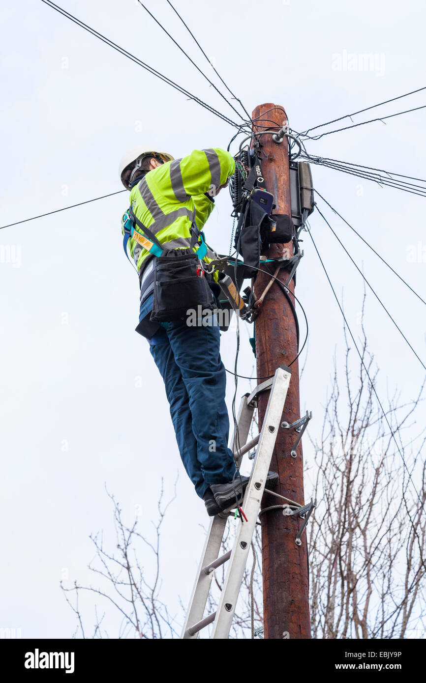 Broadband and telephone repairs. BT Openreach engineer at the top of a