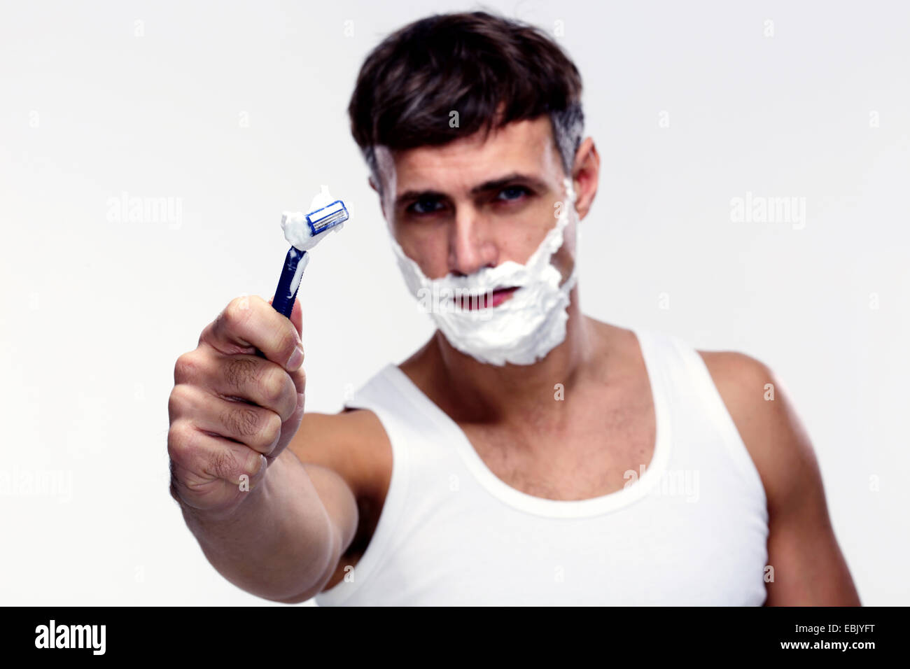 Portrait of young man shaving. Focus on shaver Stock Photo Alamy