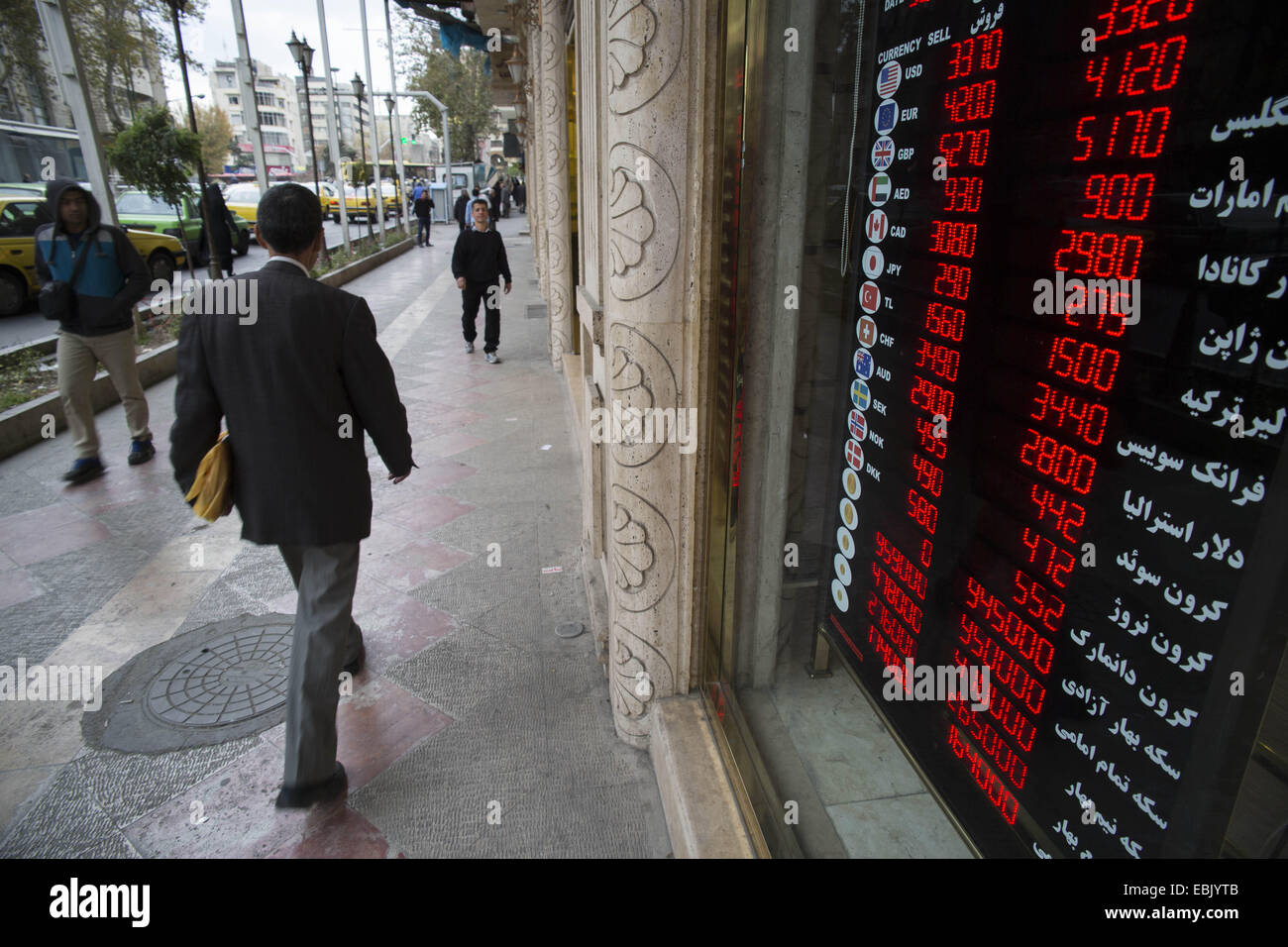 Tehran, Iran. 2nd Dec, 2014. December 2, 2014 - Tehran, Iran - An Iranian man walks past a currency exchange shop in Ferdowsi street in Tehran's business district. Ferdowsi street is the main place for the foreign currency exchange shops and foreign currency dealers in the Capital. Morteza Nikoubazl/ZUMAPRESS © Morteza Nikoubazl/ZUMA Wire/Alamy Live News Stock Photo