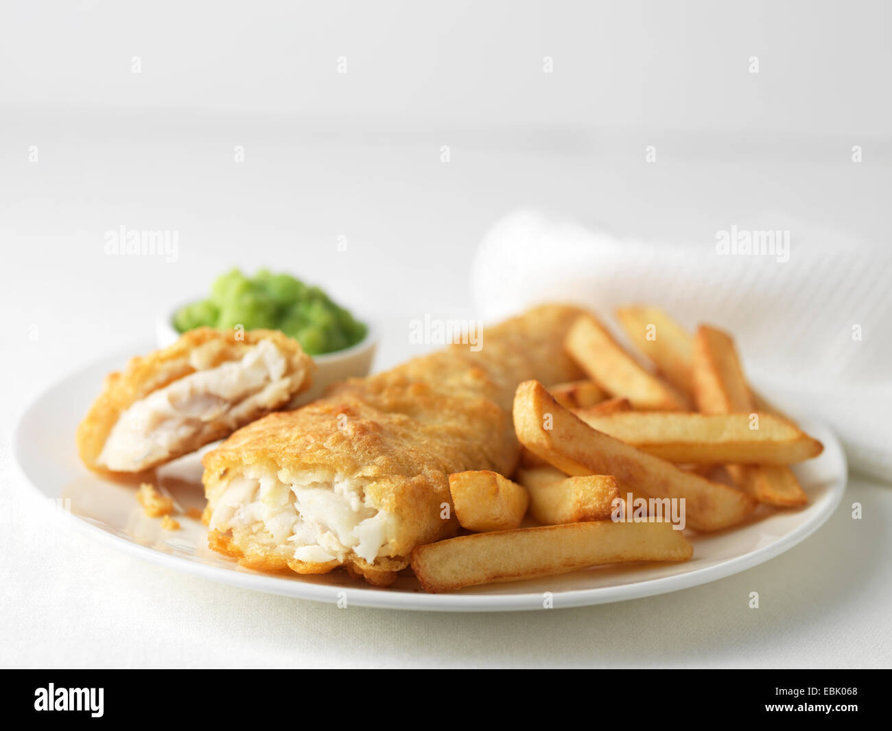 Plate of battered cod and chips with mushy peas Stock Photo