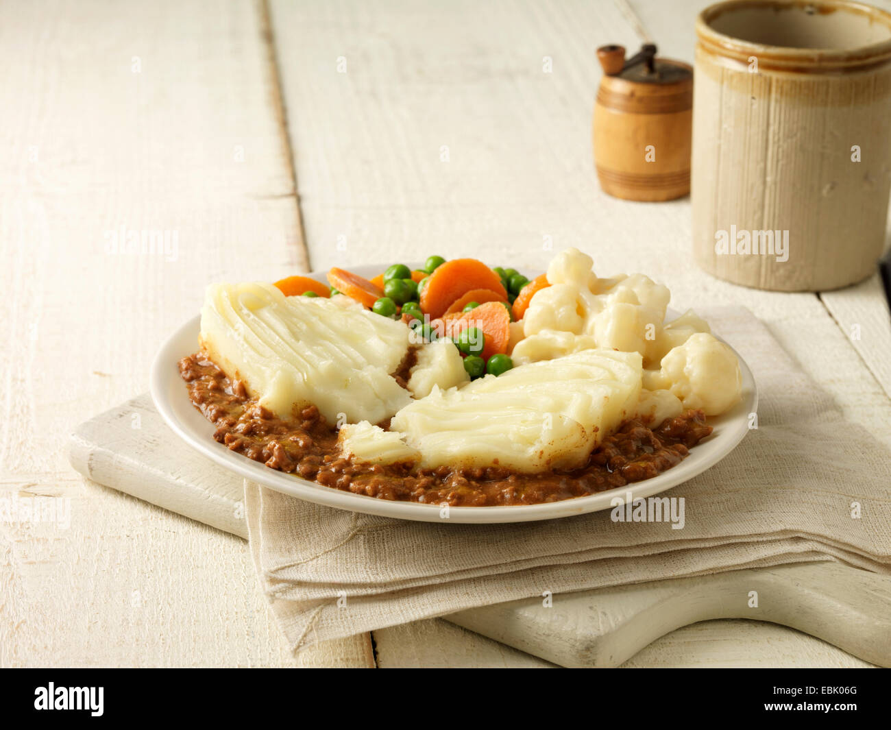 Plate of cottage pie with cauliflower cheese, peas and carrots Stock