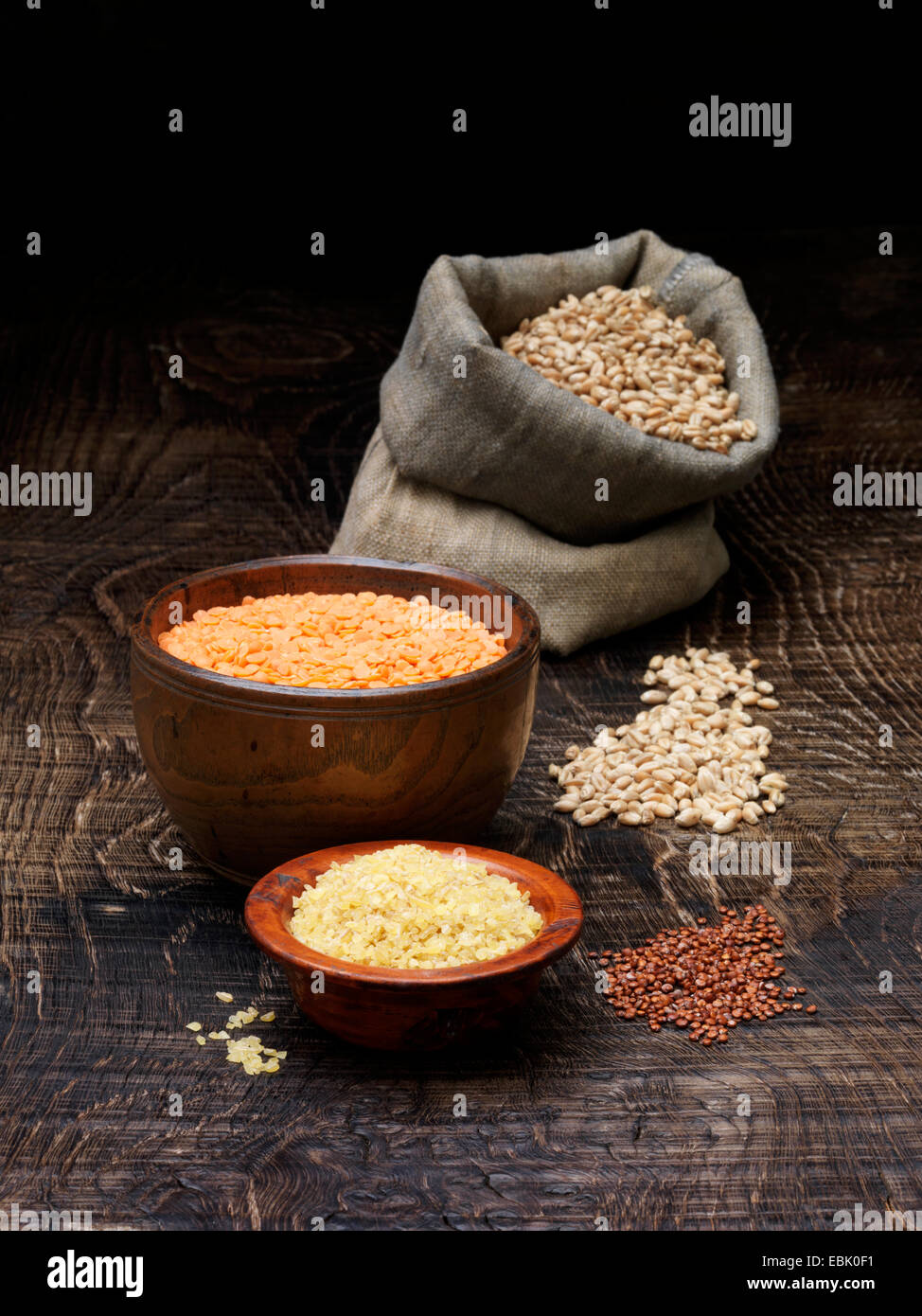 Still life with bowls of red lentils and grains with sack of seeds Stock Photo