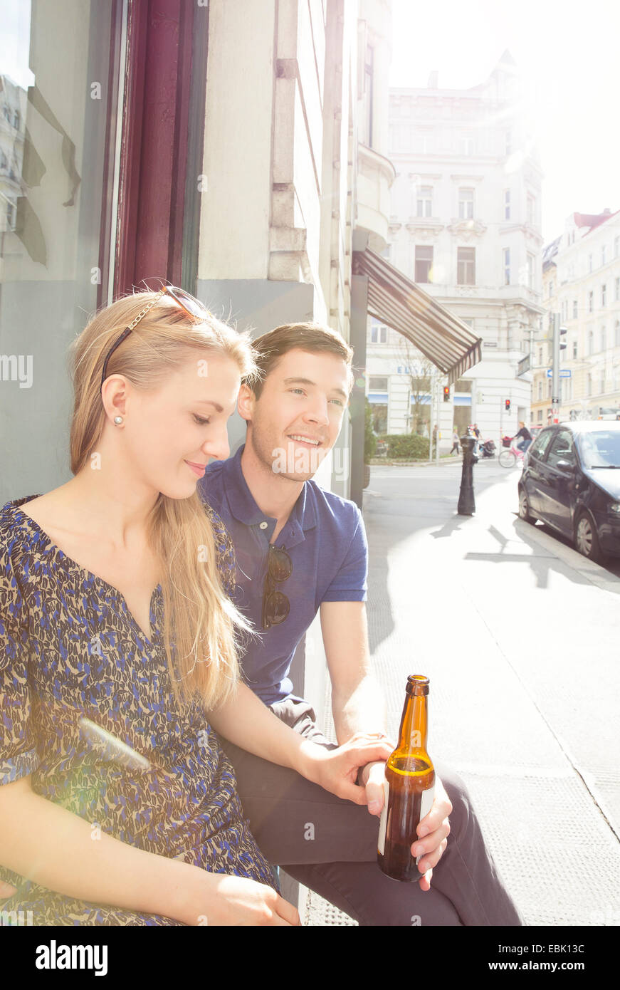 Young couple at sidewalk cafe drinking beer Stock Photo