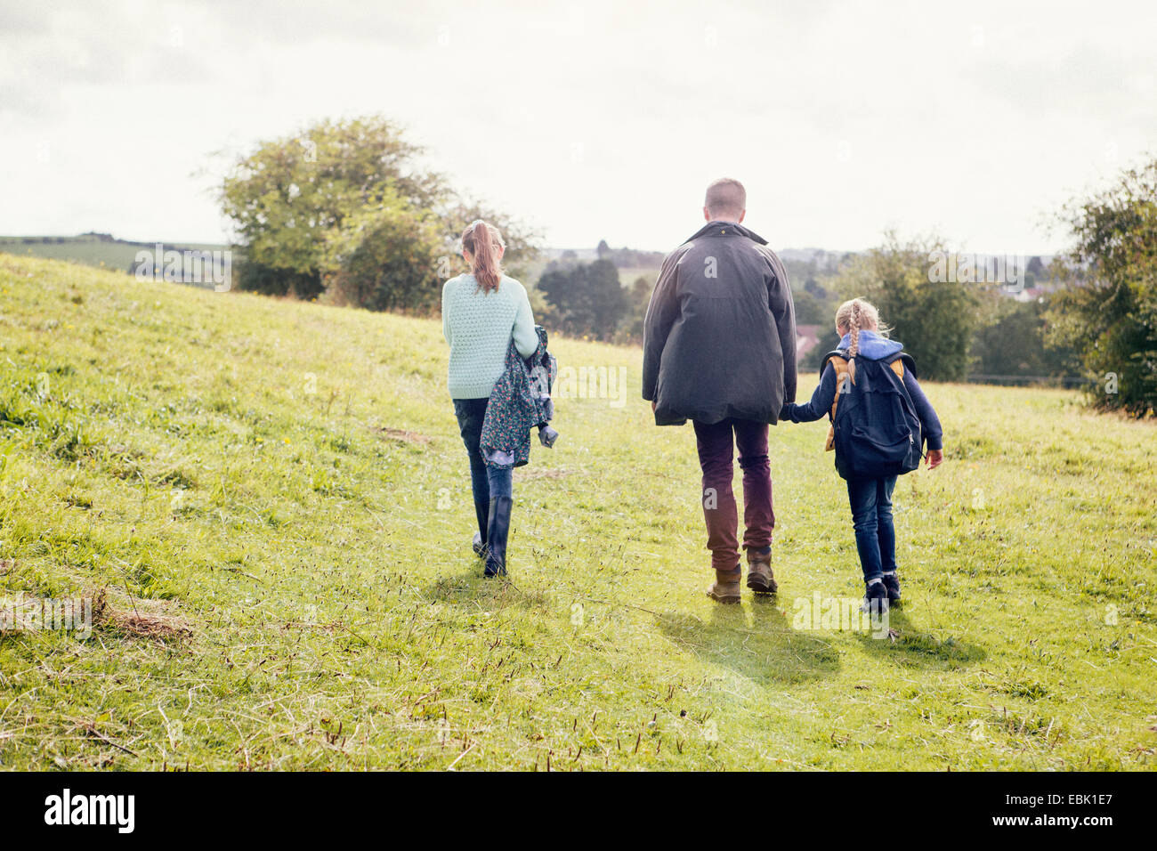 Father and daughters walking in field Stock Photo - Alamy