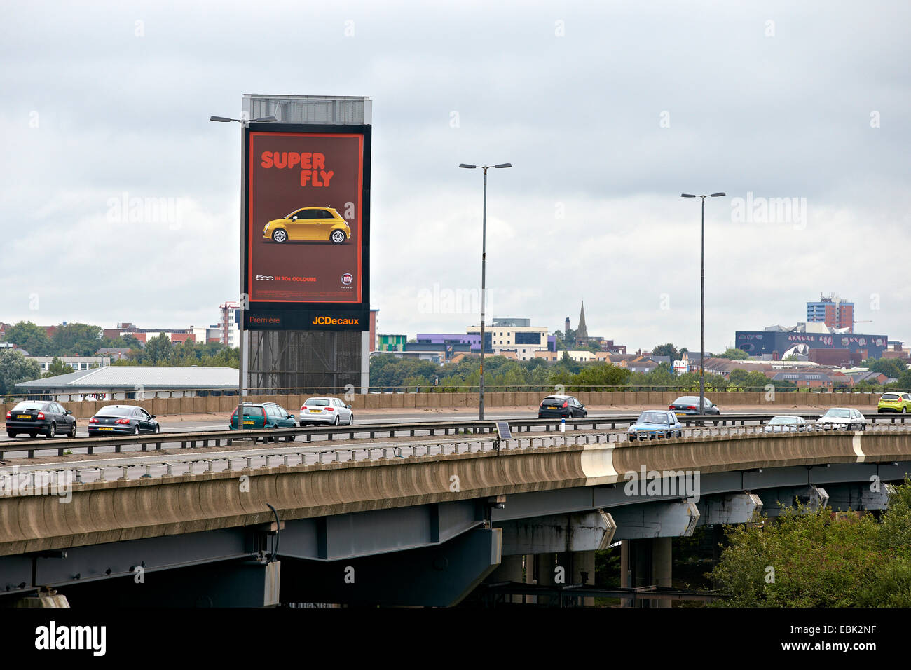 Cars pass an Illuminated roadside advertising board next to the M5 motorway, Oldbury, Birmingham. Between junctions 3 and 2. Stock Photo