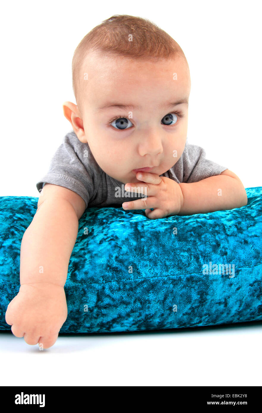 baby lying on the belly on a velvet pillow Stock Photo