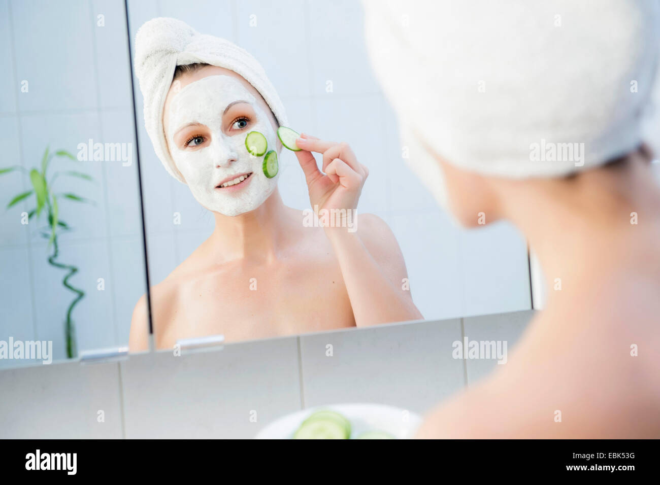 woman in bathroom with cucumber face masque Stock Photo