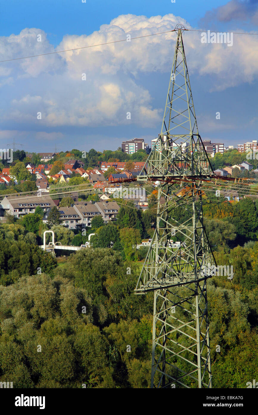 power pole in front over forest and housing area in the Ruhr valley near Essen, Germany, North Rhine-Westphalia, Ruhr Area, Essen Stock Photo