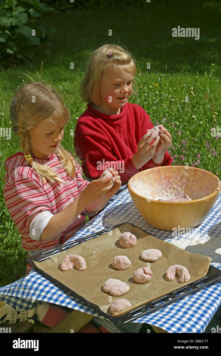 children baking dread fruit bread rolls out of bread dough and raspberries, Germany Stock Photo