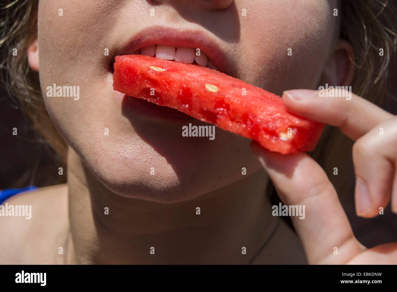 Young woman about to bite into a slice of watermelon Stock Photo