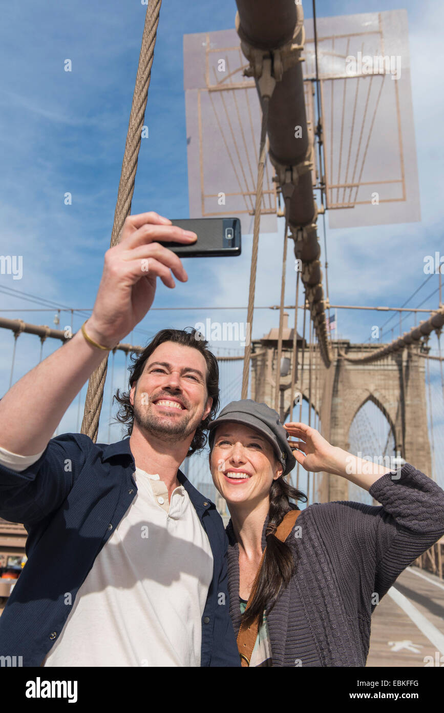 USA, New York State, New York City, Brooklyn, Happy couple taking selfie on Brooklyn Bridge Stock Photo