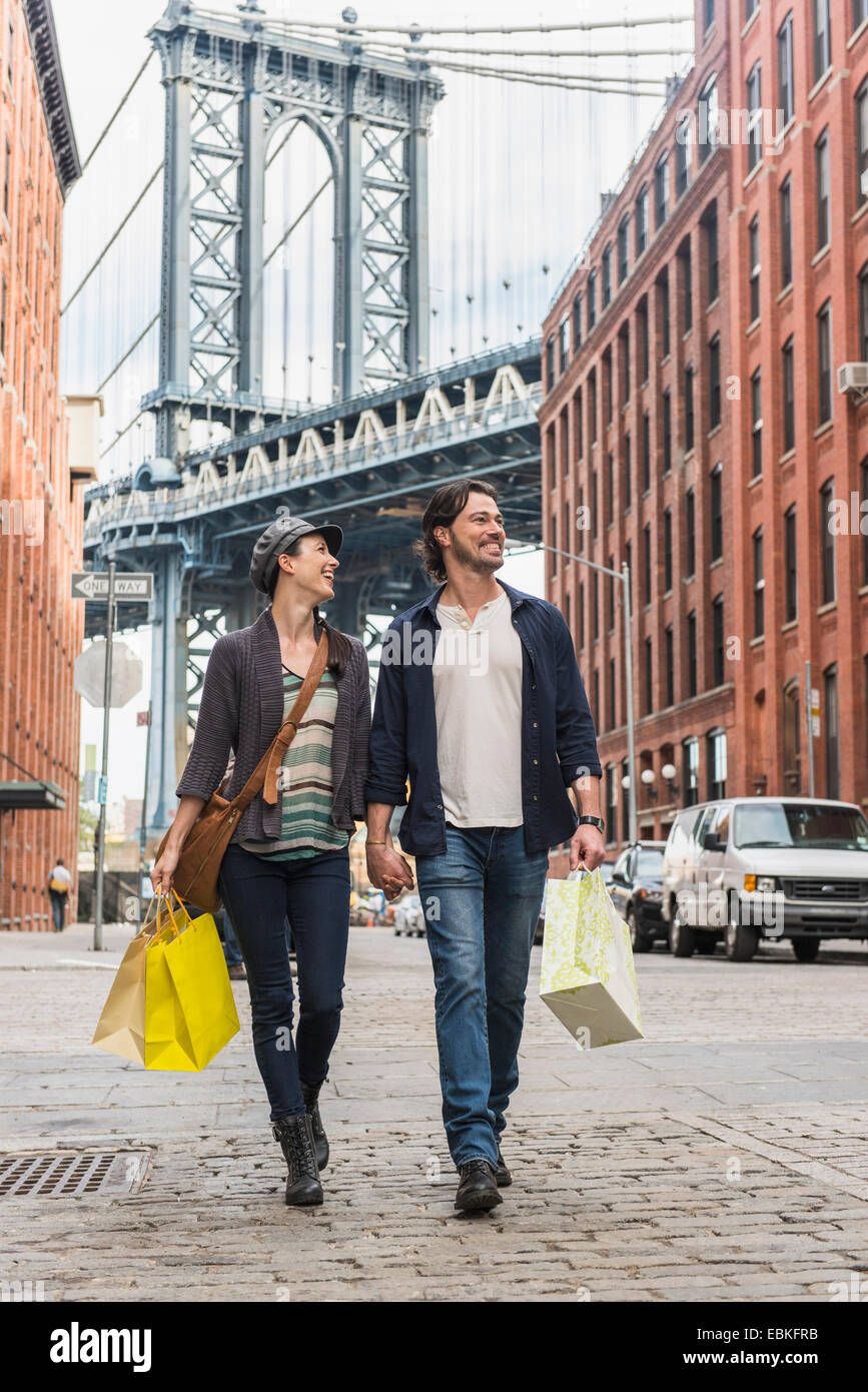 USA, New York State, New York City, Brooklyn, Couple walking on street, Brooklyn Bridge in background Stock Photo