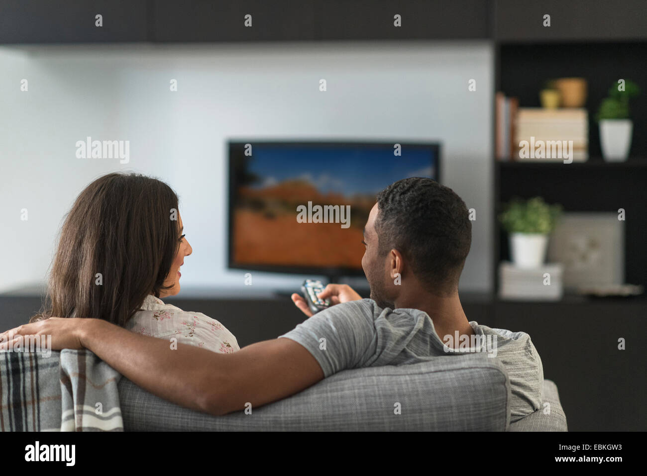 Couple sitting in living room and watching TV Stock Photo