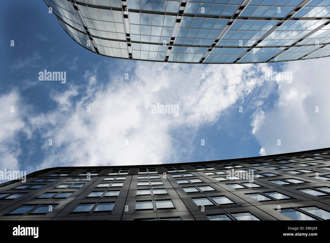 Looking up to the sky between glass tower blocks. Stock Photo